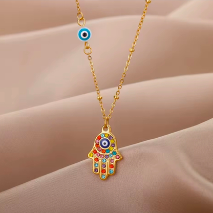 Necklace with a colorful Hamsa hand pendant on a beige background