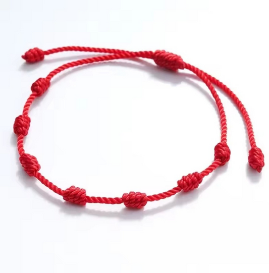 Red knotted bracelet on a white background