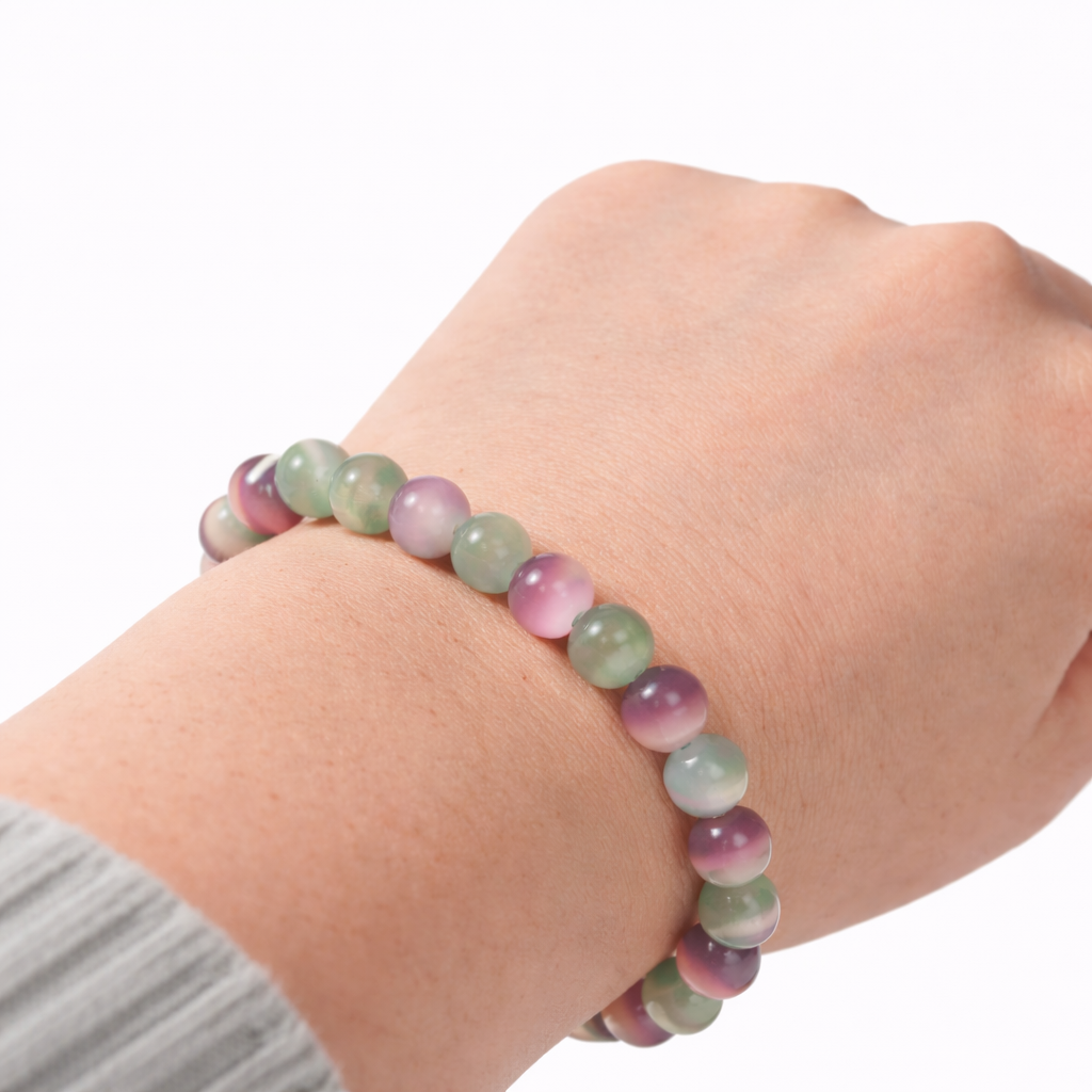 Multicolored beaded bracelet on a wrist against a white background