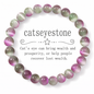 Catseyestone bracelet with purple and green beads on a white background