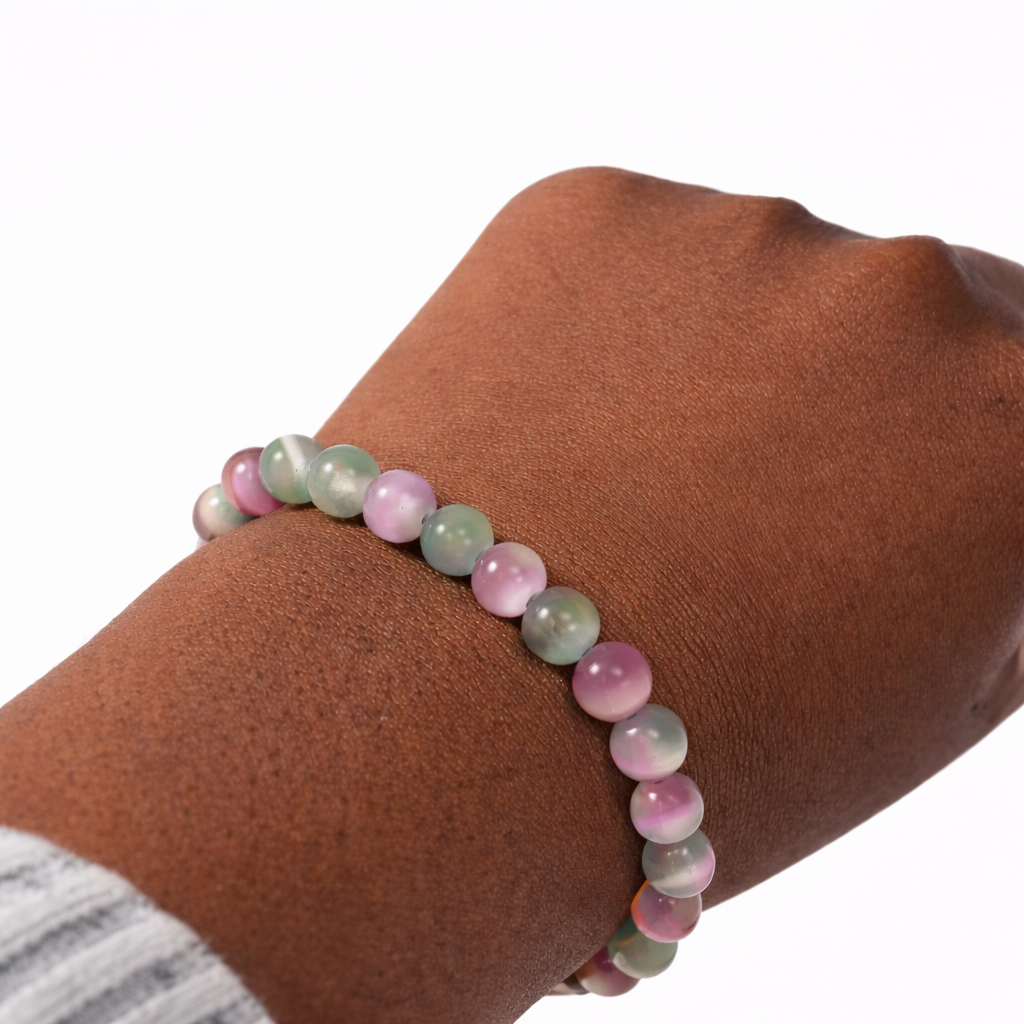 Multicolored beaded bracelet on a wrist against a white background